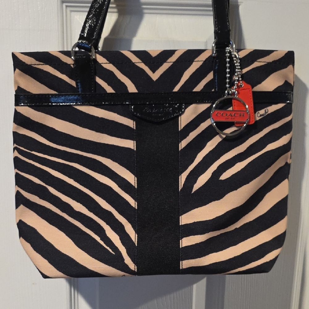 Signature Stripe Zebra Print model feat black patent leather trim and handles